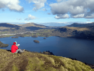 A hillwalker stops to enjoy lunch atop Catbells in the Lake District.